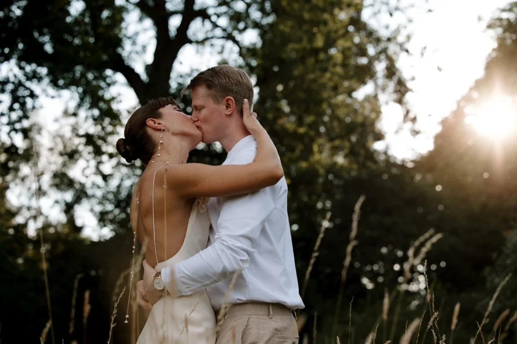 Couple kissing on wedding day at golden hour
